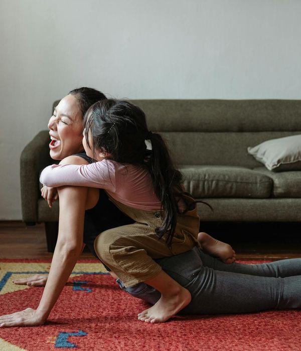 Woman smiling while doing a simple and accessible yoga stretch.